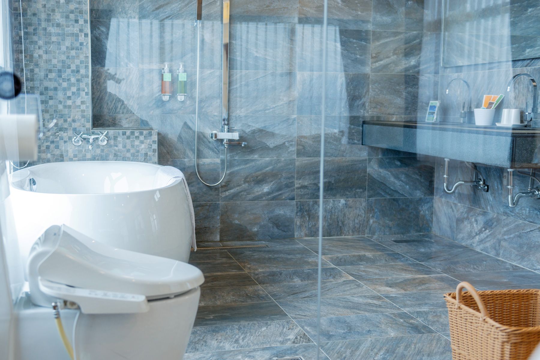 A modern bathroom with a bathtub, toilet, and shower area.