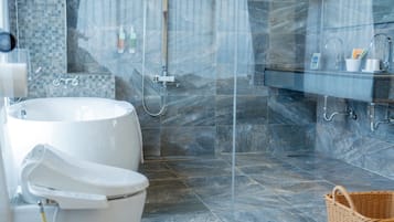 Un baño moderno con bañera, inodoro y zona de ducha.