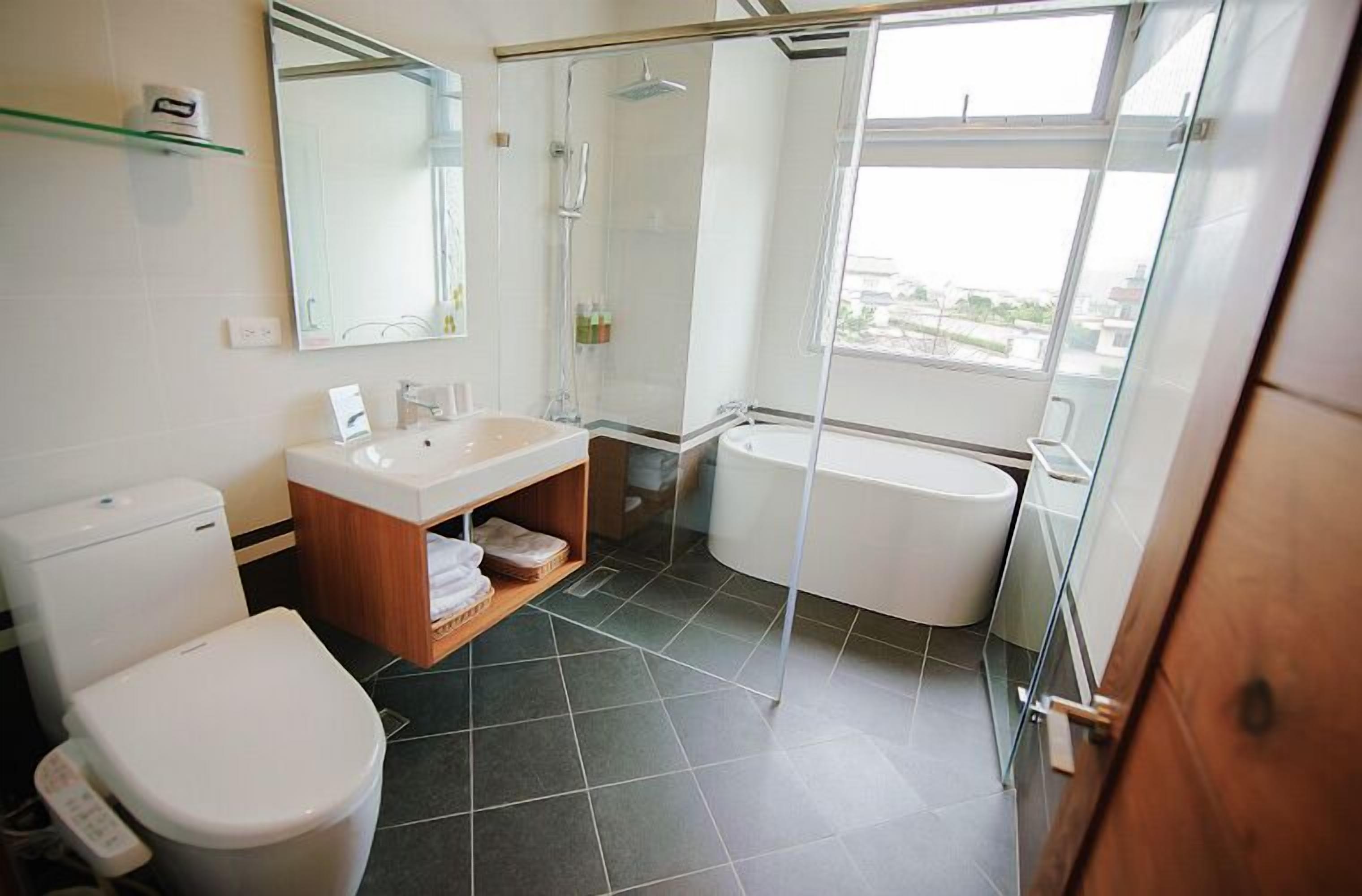 Un baño moderno con inodoro, lavamanos y bañera.