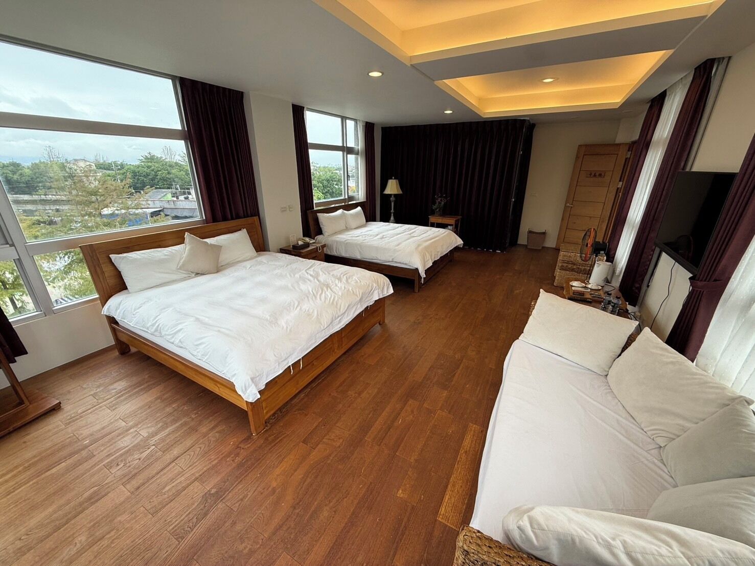 Una habitación de hotel con dos camas, un sofá y una televisión.