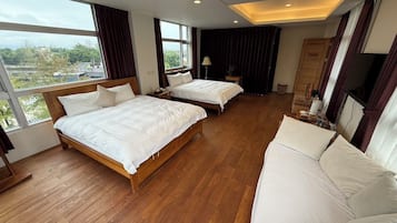 Una habitación de hotel con dos camas, un sofá y una televisión.