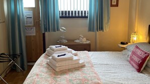 A hotel room with a bed, a vanity with a mirror, a bedside table with a lamp, and a window with curtains. - Aberdeen City Centre Apartment With Private Balcony. (Aberdeen)
