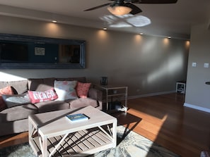 Una sala de estar con sofá, mesa de centro y ventilador de techo.