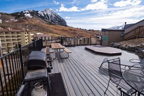 A deck with outdoor seating, a barbecue grill, and a view of a mountain. - Snowcrest Condo, short walk from lifts (Crested Butte)