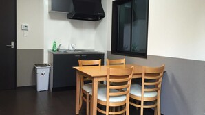 Una cocina compacta con campana extractora negra, un lavamanos pequeño y una ventana sobre la encimera.