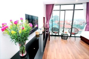 Deluxe Quadruple Room | Living area | 35-inch LCD TV with cable channels, TV