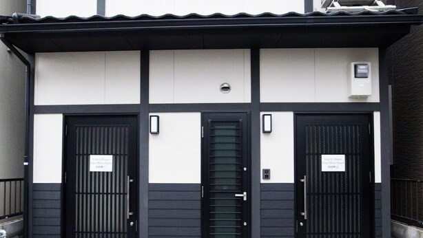 A building with three black doors, each with a sign above. - GH One More Heart at Toji 1 (Kyoto)