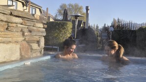 A hot spring area with stone walls and a statue in the background. - Lansdown Peaks Apartments (Wanaka)
