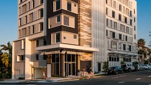 A modern hotel with a prominent entrance, multiple floors, and a clear view of the street. - Woodroffe Hotel (Southport)