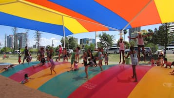 A water park with colorful slides and a large umbrella providing shade.