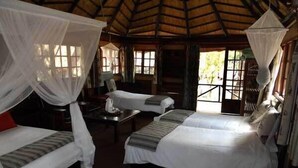 Een kamer met twee bedden, elk met een hemelbed, en een klein tafeltje.