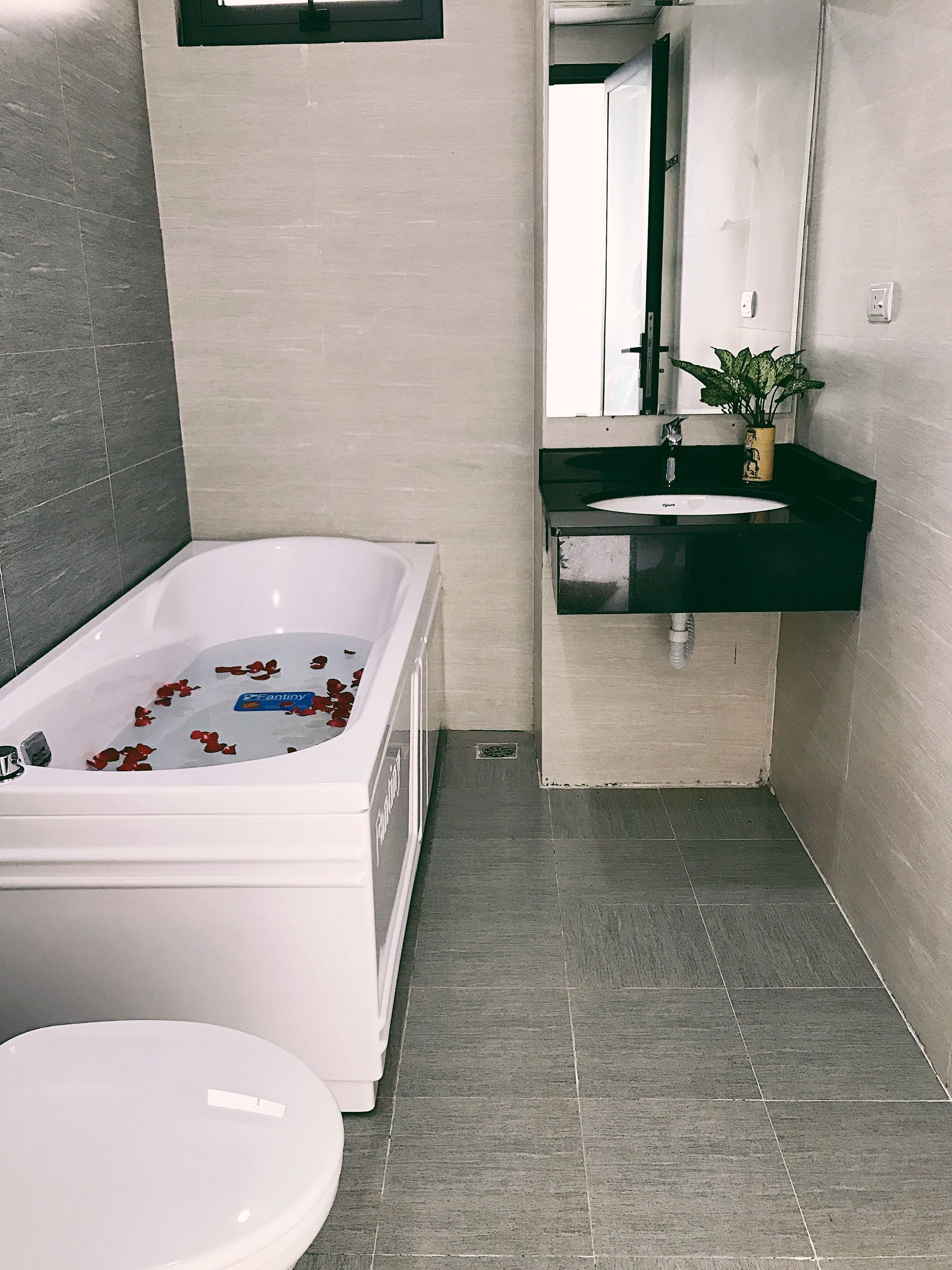 A modern bathroom with a bathtub, toilet, and sink.