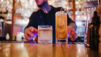 A bar setting with a tall glass of beer and a shorter glass of water on the counter.
