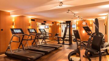 A modern gym with treadmills, weight machines, and exercise mats.