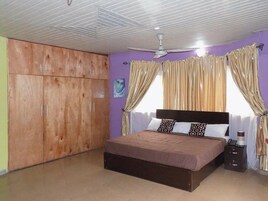 Un dormitorio con cama, armario y ventilador de techo.