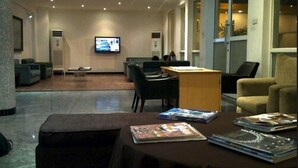 A modern lobby with a reception desk, seating area, and a television screen. - Karma Hotel (Lagos)