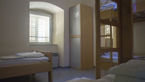 Un dormitorio con literas, una cama individual, una ventana y un armario.