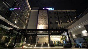 Entrada de hotel con un llamativo letrero 'FORRIZ', fachada moderna y área de acceso bien iluminada.