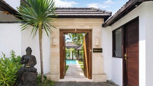 A villa entrance with a statue, a pool, and a sign reading 'BEWA VILLA'. - Villa Bewa by Villa Finder (Seminyak)