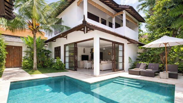 A two-story house with a swimming pool, large windows, and a balcony. - Villa Bewa by Villa Finder (Seminyak)