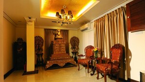 A room with a chandelier, ornate wooden furniture, and a large window with curtains. - Union Square Hotel (Yangon)