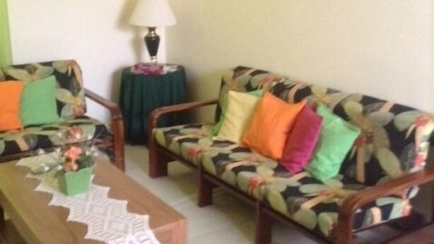 Uma sala de estar com dois sofás, uma mesa de centro e uma mesa lateral com uma luminária.