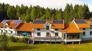 Una casa grande con varias habitaciones, rodeada de un bosque.