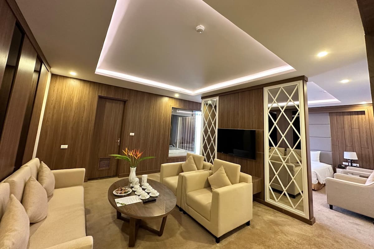Una sala de estar moderna con un sofá, sillones, una mesa de centro y un televisor.