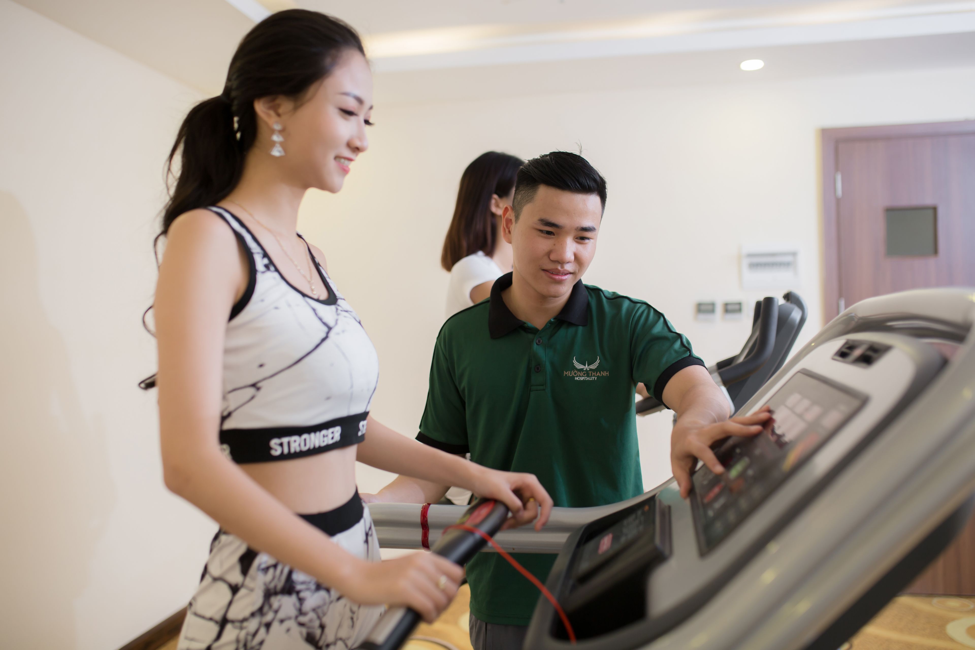 A person using a treadmill in a room with a wooden floor and a door in the background.