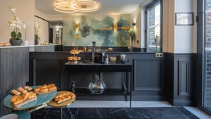 A modern kitchen with a marble countertop, a large mirror, and a decorative wall piece. - Mijo's Appartements Hôtel (Fontenay-sous-Bois)