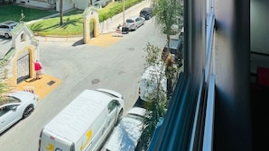 A view of a multi-story hotel with balconies, a parking area with cars, and palm trees. - Bajondillo Beach Cozy Inns (Torremolinos)
