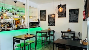 A restaurant interior with a bar area, multiple tables, and chairs. - Bajondillo Beach Cozy Inns (Torremolinos)