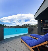 Una piscina al aire libre de temporada, sillones reclinables de piscina