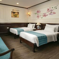 Two single beds with matching headboards and footboards, flanked by nightstands and lamps, create a warm ambiance.