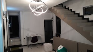 Un intérieur moderne avec un escalier, un bureau avec une chaise et une poubelle.