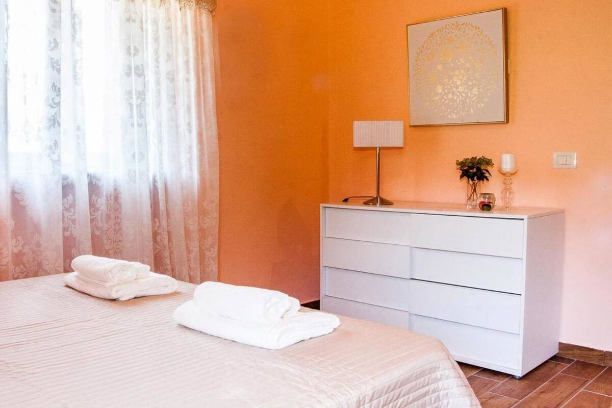 Ein Hotelzimmer mit Bett, Schminktisch, Lampe und einem Bild an der Wand.