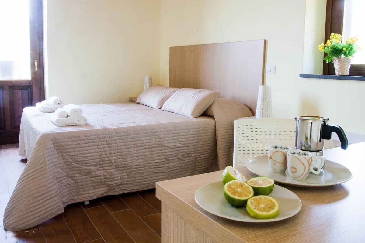 Ein Hotelzimmer mit Bett, Kaffeemaschine und einer Tellert mit Limettenscheiben.