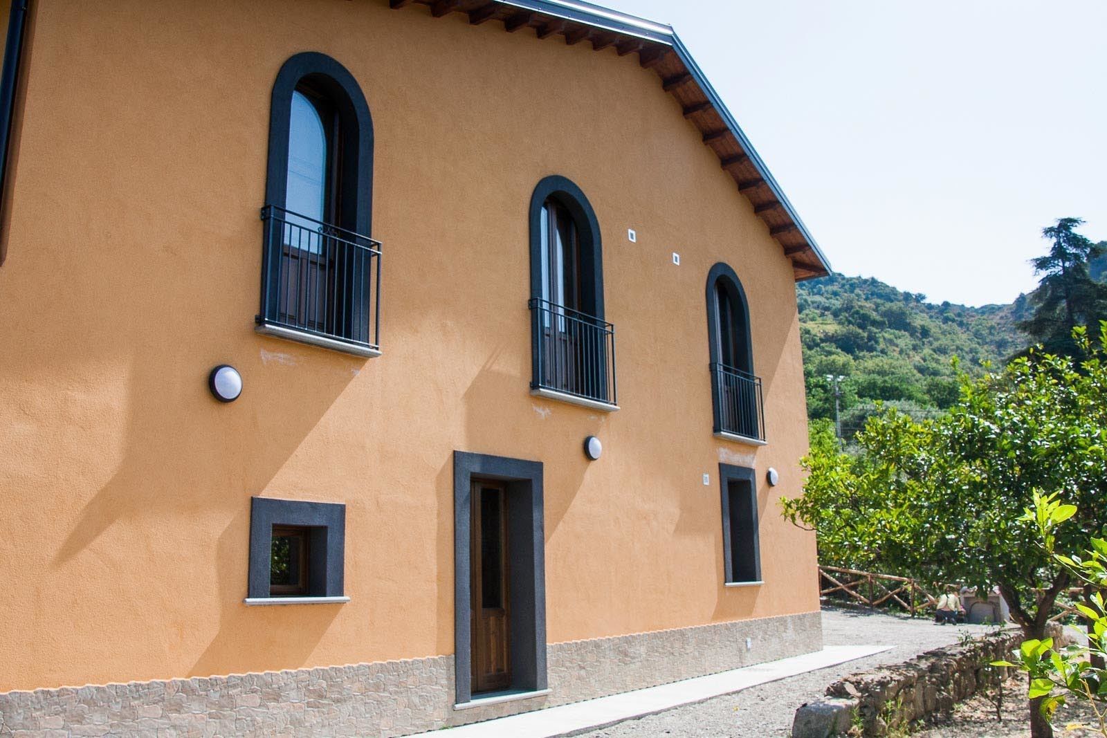 A building with three arched windows and a stone base.