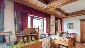 A cozy kitchen with wooden cabinets, a stove, and a dining area with a table and chairs. - Hotel bayrischer Löwe (Osterhofen)