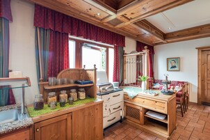 Uma cozinha acolhedora com armários de madeira, fogão e uma área de jantar com mesa e cadeiras.