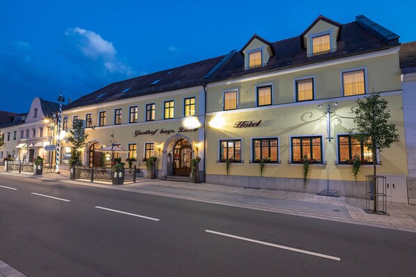 Un hotel de estilo arquitectónico europeo clásico, con una entrada destacada que incluye un toldo y un letrero.