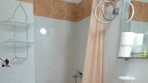 A bathroom with a toilet, shower, sink, and tiled walls. - Hotel Argo (South Pelion)