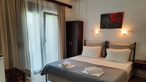 A hotel room with a bed, a wardrobe, a desk, and a window with curtains. - Hotel Argo (South Pelion)