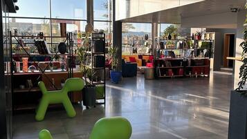 Un interior espacioso y luminoso, con grandes ventanales, muebles modernos y una variedad de plantas.