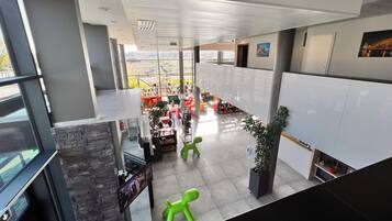 Un interior moderno con comedor, asientos y vistas al exterior.