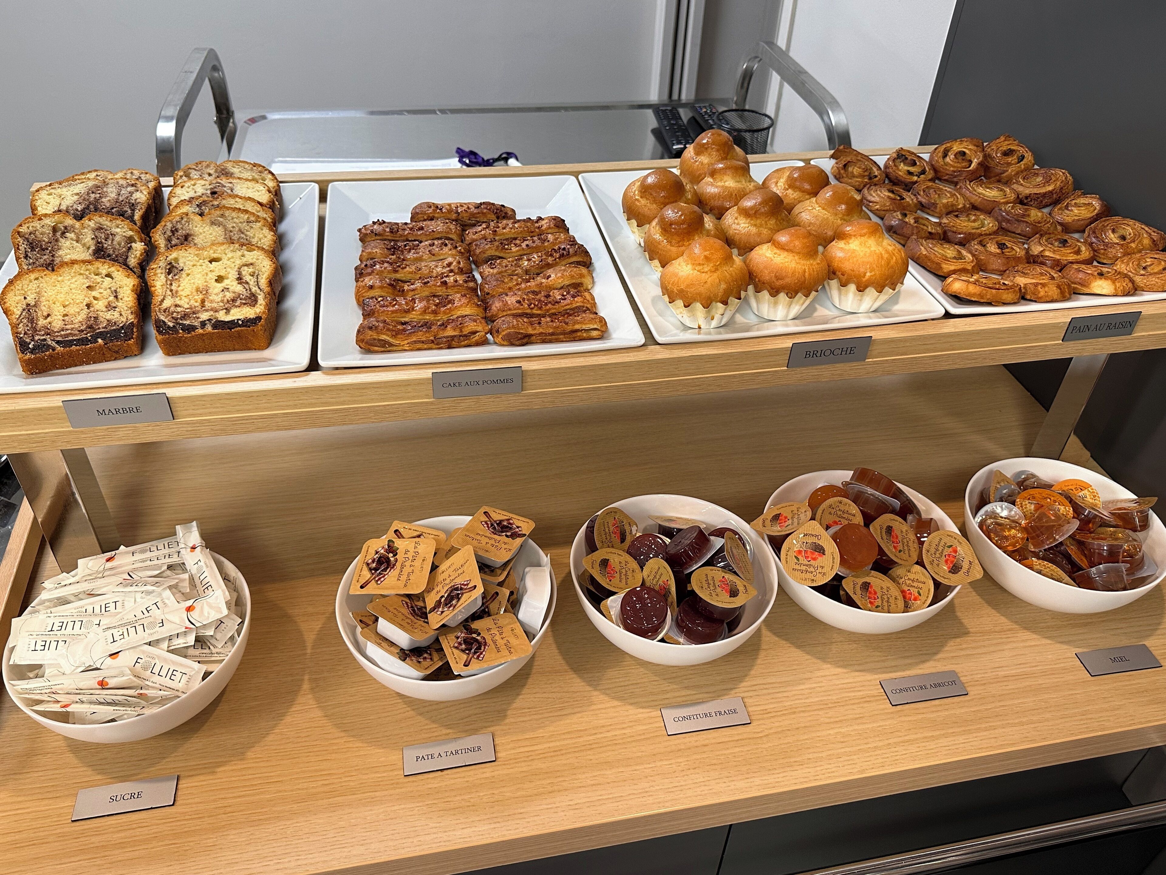 Eine Bäckertheke mit verschiedenen Backwaren und beschrifteten Behältern mit Süßigkeiten.