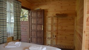 A wooden cabin room with a bed, a wooden door, and a window with curtains. - Agva Himalaya Motel (Sile)