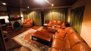 A living room with leather sofas, a coffee table, and a fireplace. - Hillsborough Cottage Nuwara Eliya (Nuwara Eliya)