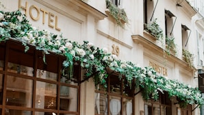 A hotel facade with large windows, a wooden door, and a sign reading "HOTEL PARISTER". - Hotel Parister & Spa (Paris)