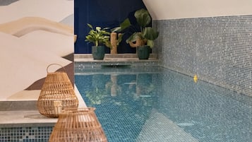 Una piscina techada, sillones reclinables de piscina